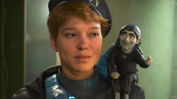 Death Stranding 2's commander of Drawbridge is standing in a narrow corridor with a ventriloquist's dummy on her shoulder